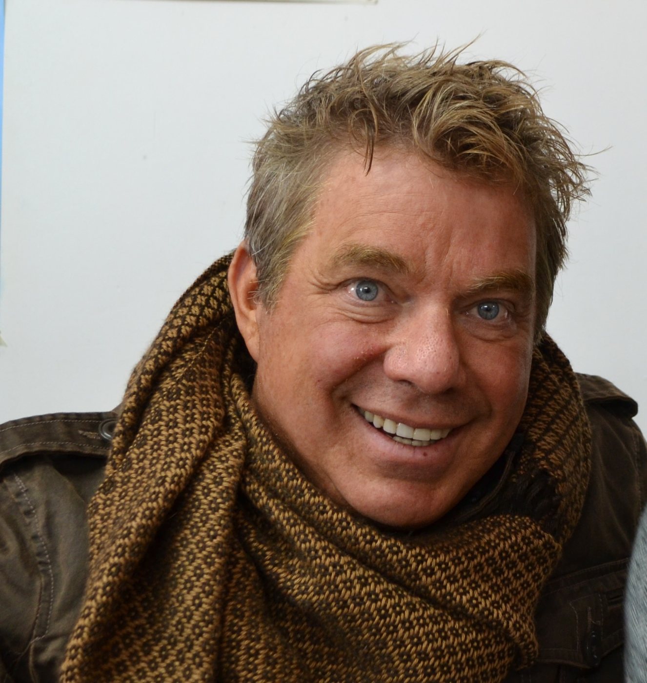 Portrait of Steve Bender smiling, wearing a woven scarf